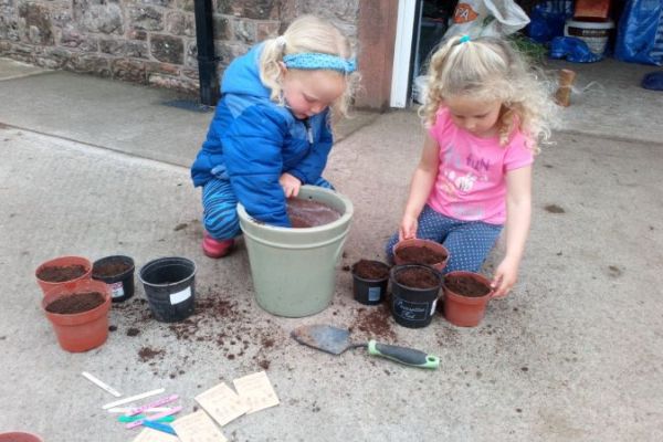 Anna and Laura planting sunflowers, peas and cress