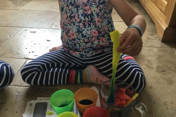 Enjoying making favourite rainbow colours by mixing.